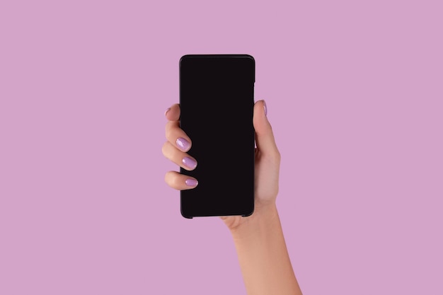 Womans hand with lavender manicure holding smartphone with blank screen