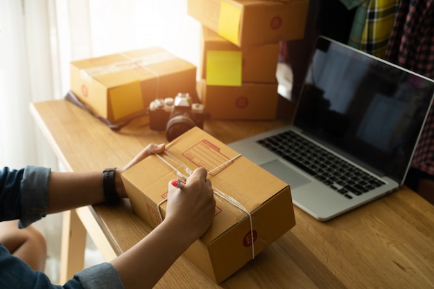 Womans hand with packing cardboard box at workplace, Online selling