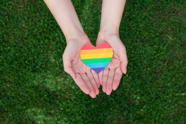 Womans hands hold heart in colors of rainbow LGBT rights Pride month