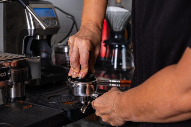 womans hands pressing roasted and ground coffee to use in coffee maker