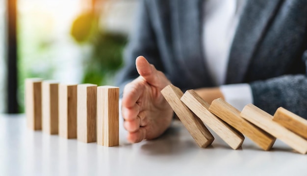 womans hands protect wooden house from dominoes symbolizing insurance safeguarding against risks