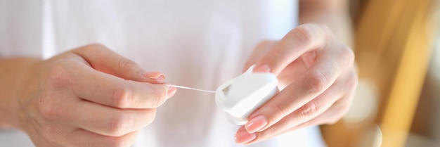 Womans hands take out dental floss from box closeup shallow depth of field dental care and