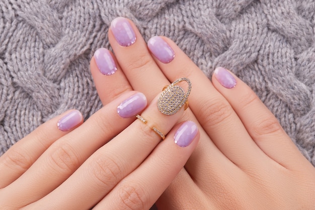 Womans hands with fashionable lavender manicure winter christmas nail design