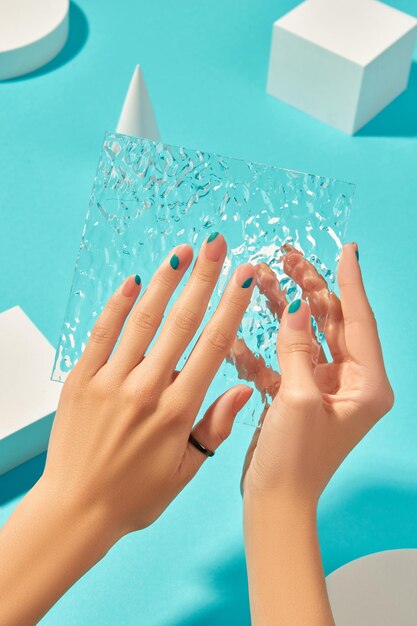 Womans hands with manicure on blue background beauty treatment concept