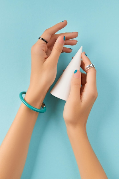 Womans hands with summer manicure on blue background