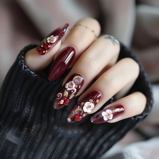 a womans nails with a red flower design on the nails