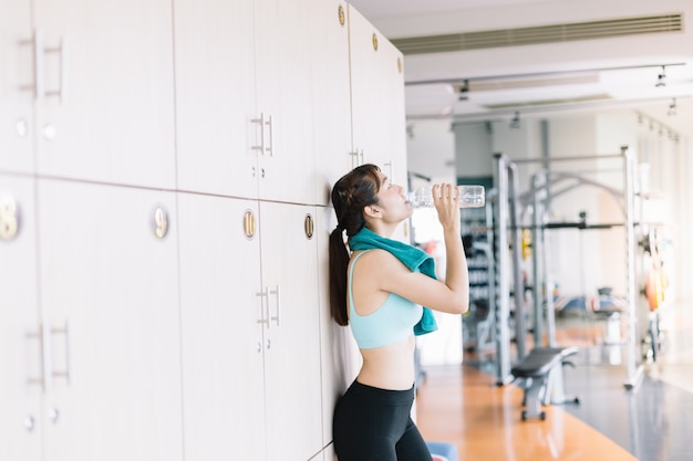 Women are drinking water after exercising in the morning gym.