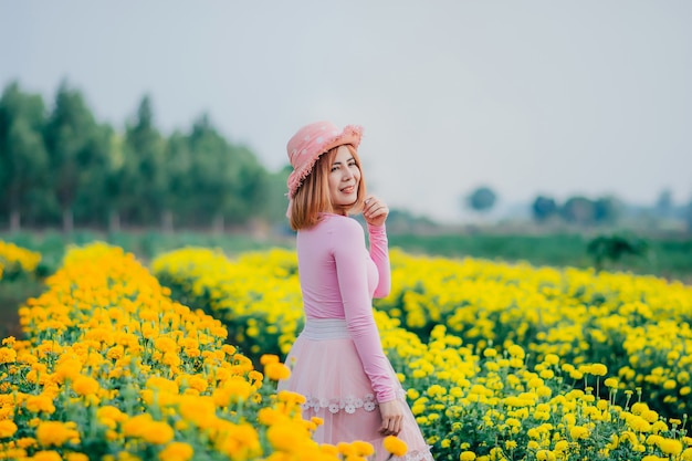 women are standing watching the flowers in the garden.