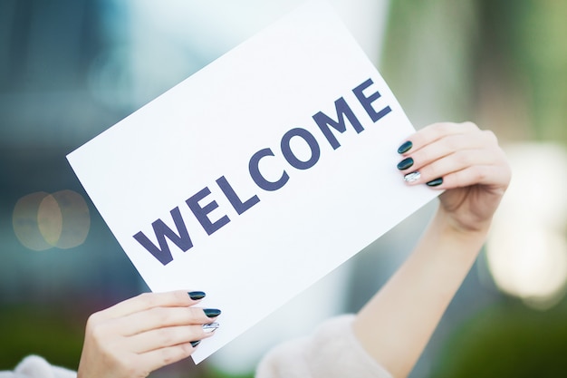 Women business with the poster with welcome message