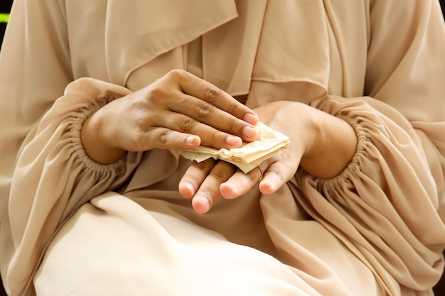 Women disinfecting his hands with a wet wipe