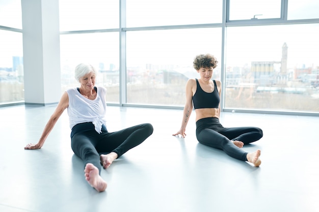 Women doing yoga next to a large window