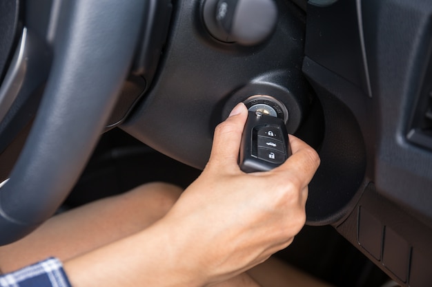 Photo women driver hand inserting car key and starting engine.