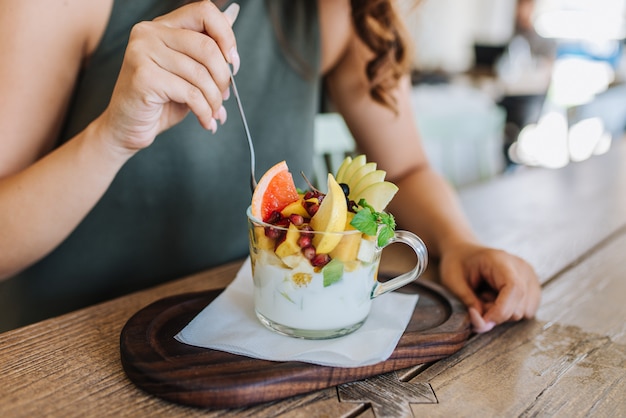 Women eating her healthy snack served on a wooden tray.