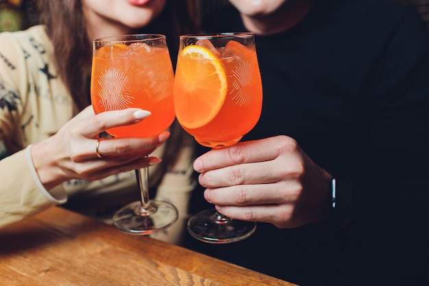 Women a glasses of aperol spritz at the dinner table.