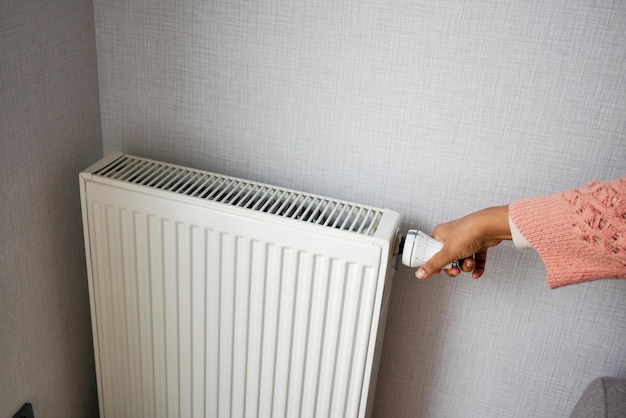 Women hand adjusting the temperature of a radiator