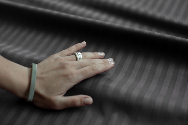 Women hand against a folded brown fabric