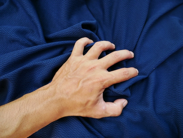 women hand and blue silk fabric background