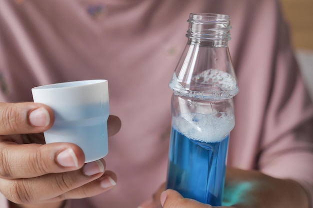 Women hand hold a mouthwash liquid container