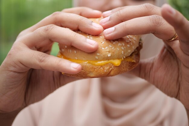 Women hand holding beef burger top view