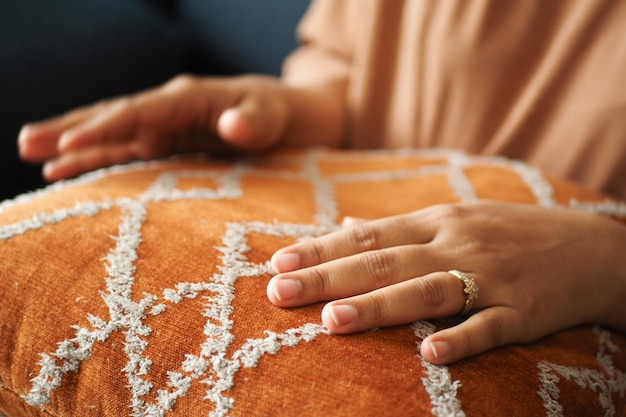 Women hand on a orange color pillow