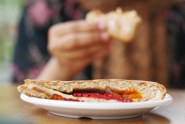 Women hand pick sandwich with ham cheese tomatoes