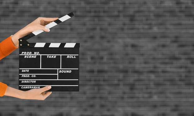 Women hands holding clapper board for making video cinema in studio.