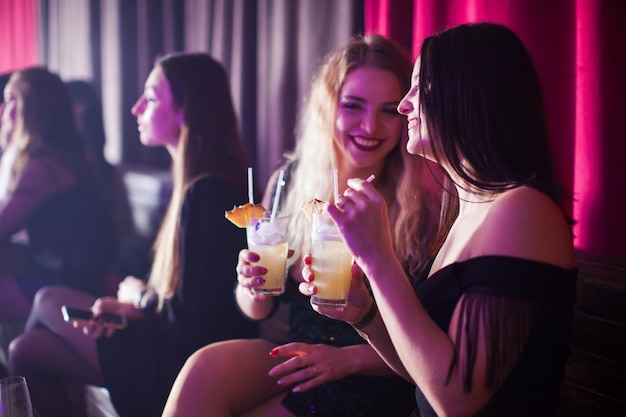 Women have fun and drinking cocktails with fruits