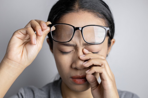 Women hold glasses and suffer from eye pain.