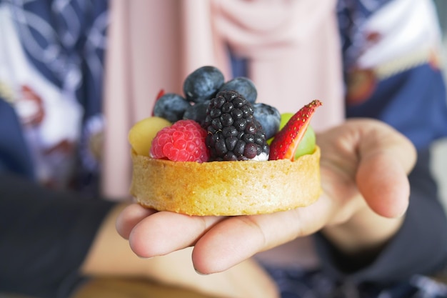 Women holding a berry fruit tart cake