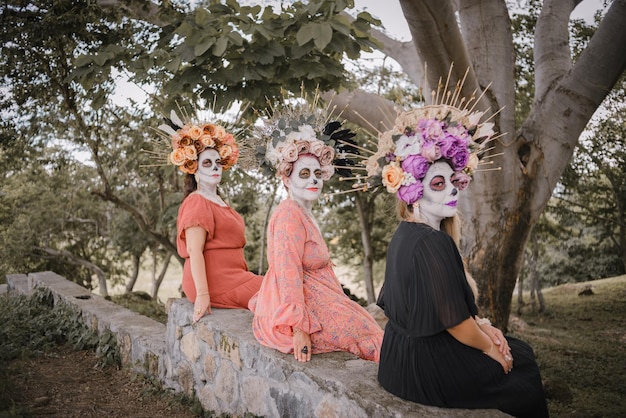 Women made up as catrinas. Day of the dead and Halloween makeup. Outdoor group portrait of three women