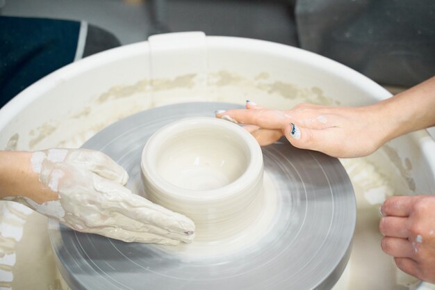 Women making ceramic pottery, concept for workshop and master class, four hands close-up