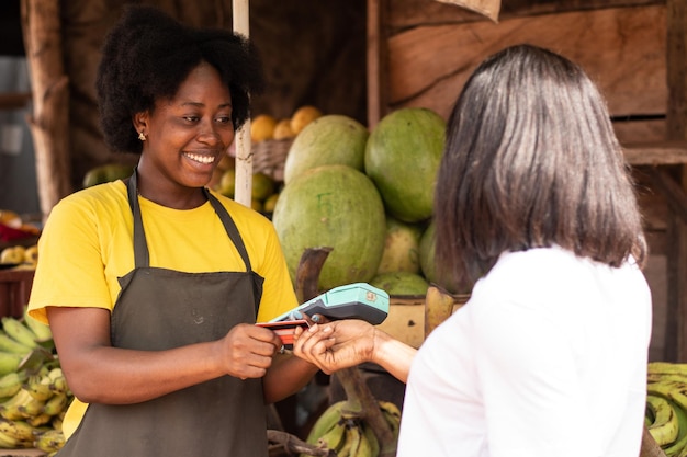 Women in a market, paying with credit card