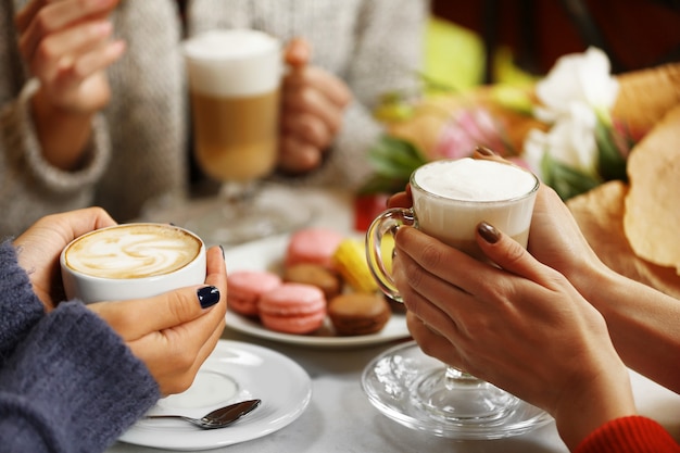 Women meeting in cafe and drinking latte