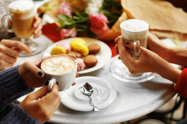 Women meeting in cafe and drinking latte