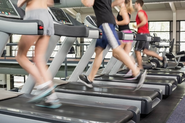 Women and men running on a treadmill at the gym