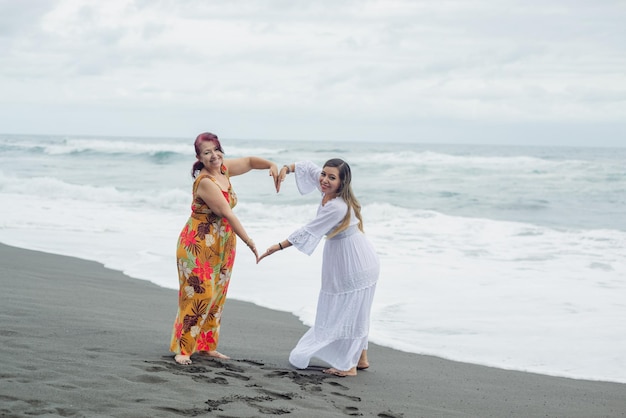 Women, mother and daughter enjoying quality time at the beach. Pacific Ocean, cloudy day.