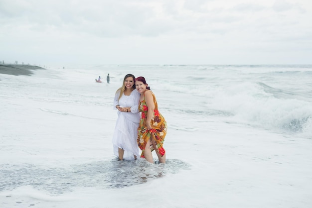 Women, mother and daughter enjoying quality time at the beach. Pacific Ocean, cloudy day.