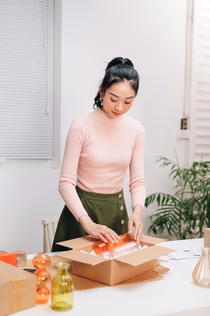 Women packing package with her products that she selling online