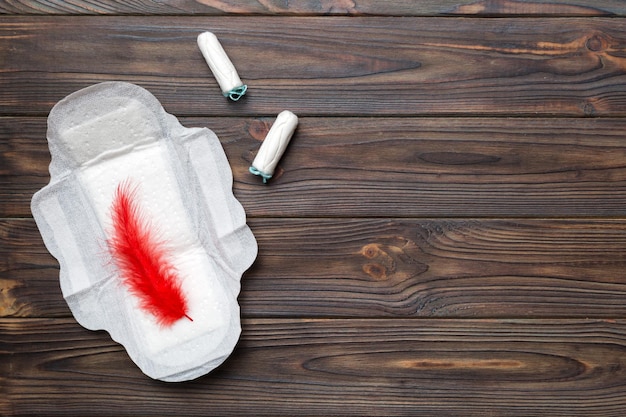 Women pads and tampon sanitary pads lies next to a tampon on an isolated background on a pink and violet background Women's hygiene and menstrual period concept