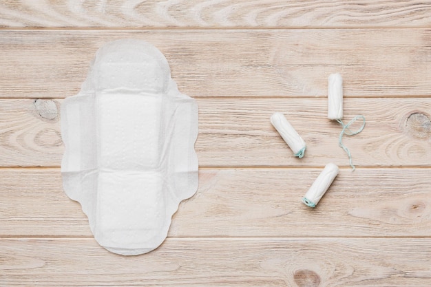 Women pads and tampon sanitary pads lies next to a tampon on an isolated background on a pink and violet background Women's hygiene and menstrual period concept