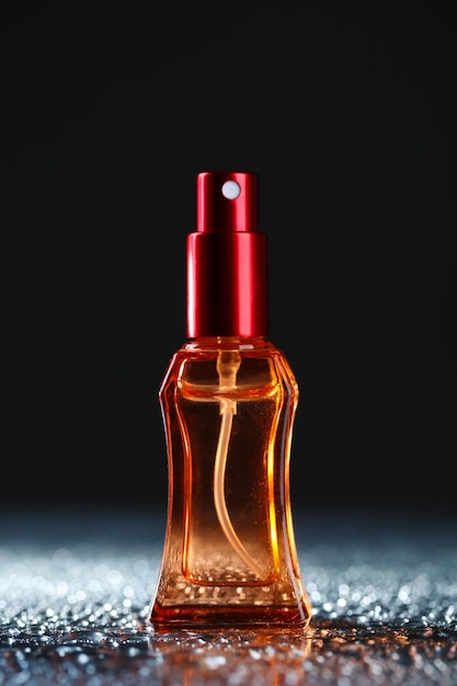 Women perfume in beautiful bottle on dark background