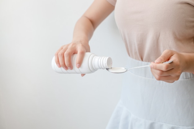 Women pouring drugs or antacids in their hands because of the food from their hands to the bottle