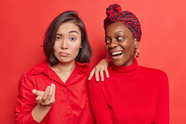 women react differently on something stand closely to each other on bright red