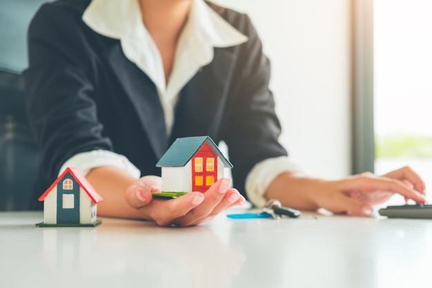 Women Real Estate Agent hold a small house model in her hand