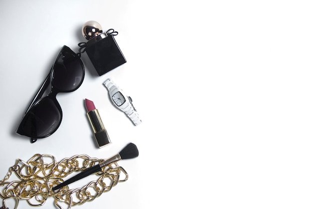 Women's accessories in black and cosmetics on a white background. Top view of the desktop for women