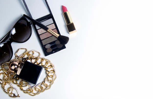 Women's accessories in black and cosmetics on a white background. Top view of the desktop for women