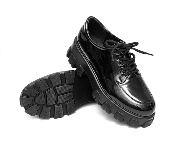 Women's black patent leather shoes with lacing on a white background