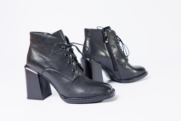 Women's boots with black genuine leather on heels isolated on a white background. photo from the side, diagonally and foreshortened from behind. Women's shoe collection 2022