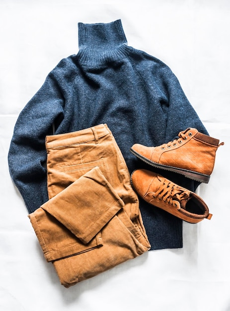 Women's clothing set autumn winter cashmere blue sweater brown corduroy jeans suede shoes on a light background top view