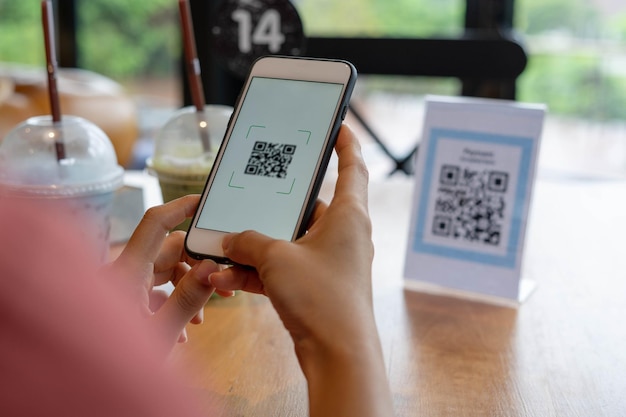 Women's hands are using the phone to scan the qr code to select food menu Scan to get discounts or pay for food The concept of using a phone to transfer money or paying money online without cash